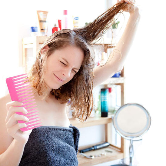 femme qui se coiffe avec peigne a cheveux anti cassure
