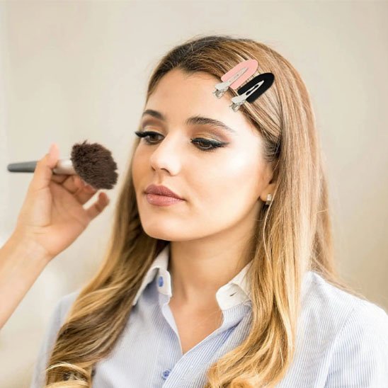 femme se maquillant avec pince a cheveux